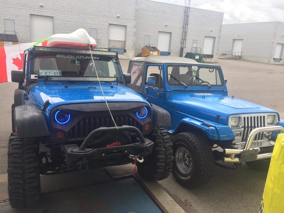 Blue Jeeps with off-road tire setups at the shop