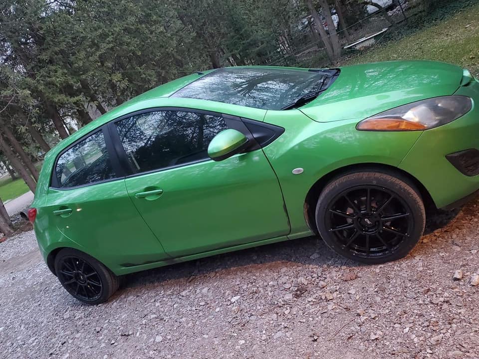Green Mazda with custom black wheels